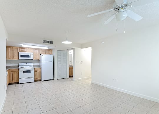 A kitchen with white appliances and wooden cabinets.