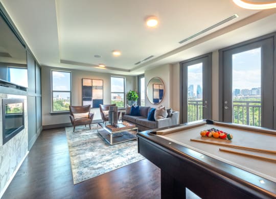 Resident sky lounge facing a pool table and sitting area complete with a television and fireplace.