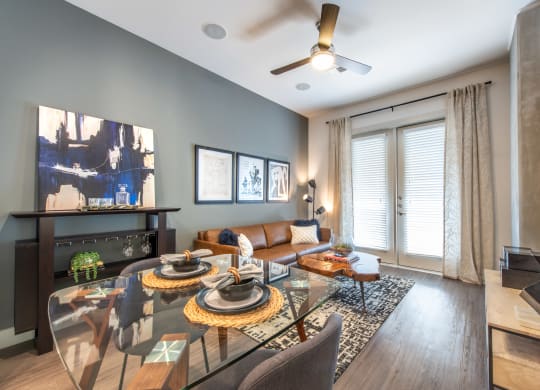 Interior of apartment living area facing exterior windows and a couch facing a television