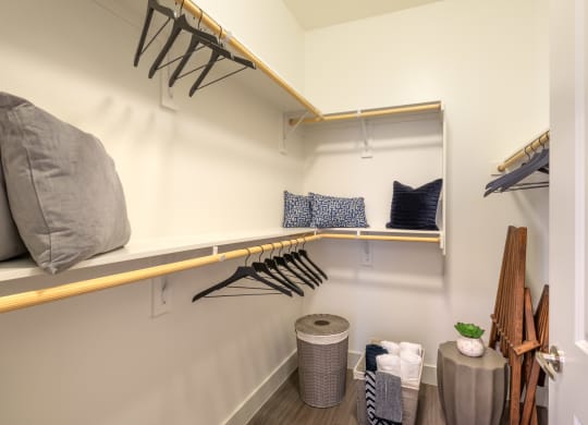 Interior of closet area with pillows and hangers stored on the shelf