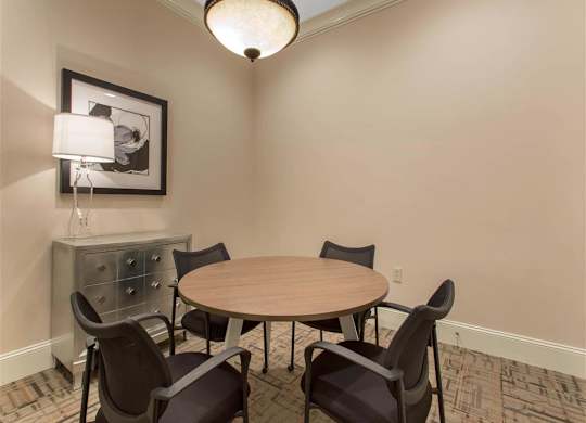 Clubhouse Seating Area with Round Dining Table with Chairs and Chest of Drawers with Art on the Wall