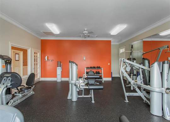 Fitness Center with Exercise Equipment with Orange and Mirror Accent Wall