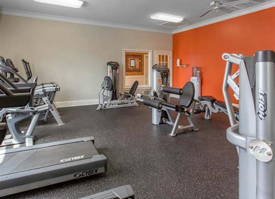 Fitness Center with Exercise Equipment with Orange and Mirror Accent Wall