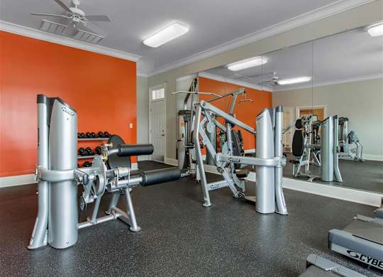 Fitness Center with Exercise Equipment with Orange and Mirror Accent Wall