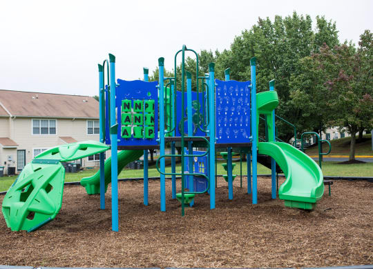 Playground with wood chips in court yard between buildings.