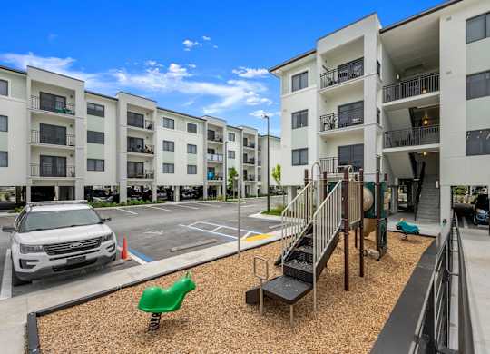 an image of a playground in front of an apartment building