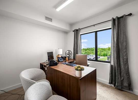 an office with a large window and a desk with a computer