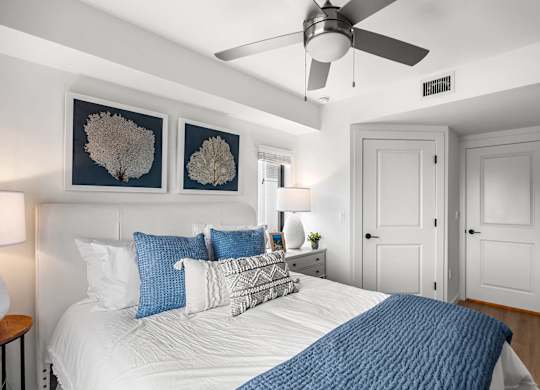 a bedroom with a large bed and a ceiling fan
