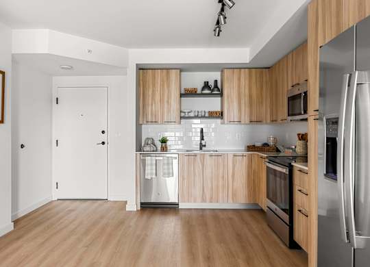 a kitchen with wooden cabinets and a stainless steel refrigerator