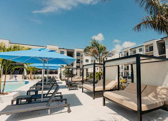a pool with lounge chairs and umbrellas