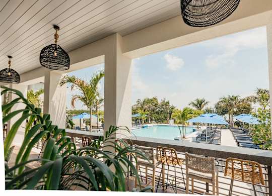 a balcony with a view of a swimming pool and palm trees