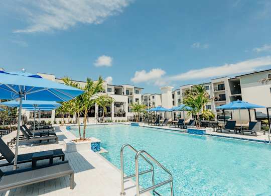a swimming pool with lounge chairs and umbrellas at the resort