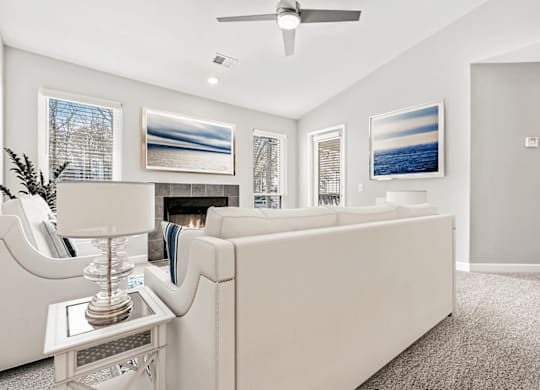 A living room with a white couch and a ceiling fan at Paces Pointe Apartment Homes, Matthews, NC