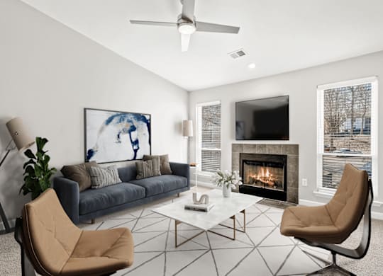 A living room with a fireplace and a painting of a woman at Paces Pointe Apartment Homes, Matthews, NC