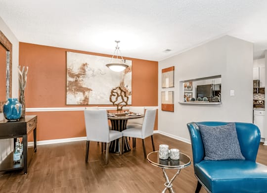 A blue leather chair sits in a room with orange walls at Paces Pointe Apartment Homes, Matthews