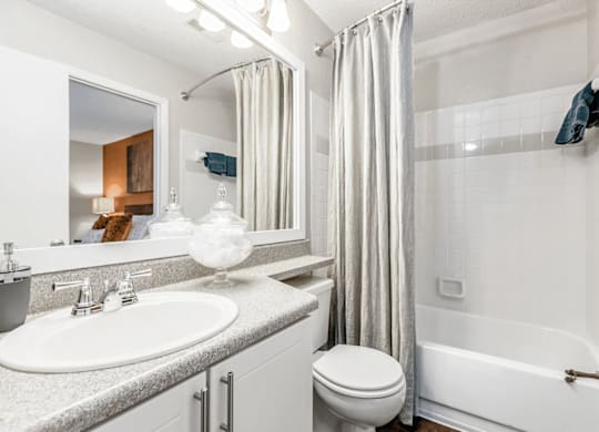 A white bathroom with a sink, toilet, and bathtub at Paces Pointe Apartment Homes, Matthews, NC, 28105