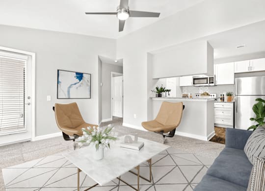 A modern living room with a white coffee table and two chairs at Paces Pointe Apartment Homes, Matthews, NC, 28105