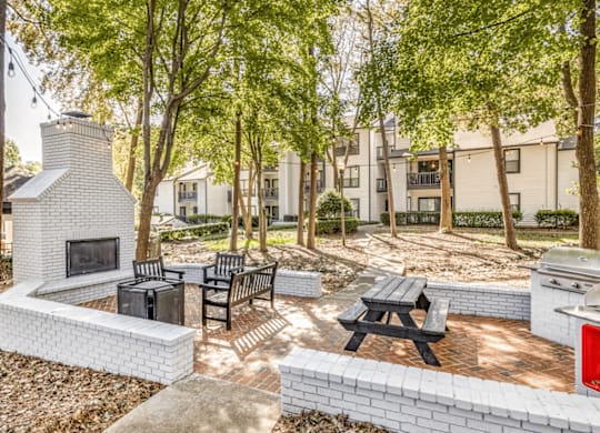 A patio with a fireplace and seating area at Paces Pointe Apartment Homes, Matthews, NC