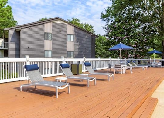 a large deck with lounge chairs and umbrellas at The Parke at Trinity Apartment Homes, North Carolina, 27607