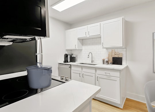 a kitchen with white cabinets and a white counter top at The Parke at Trinity Apartment Homes, North Carolina, 27607
