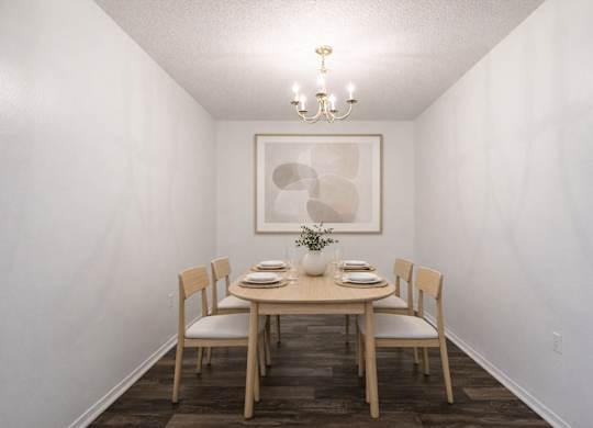 A dining room with a table set for two.