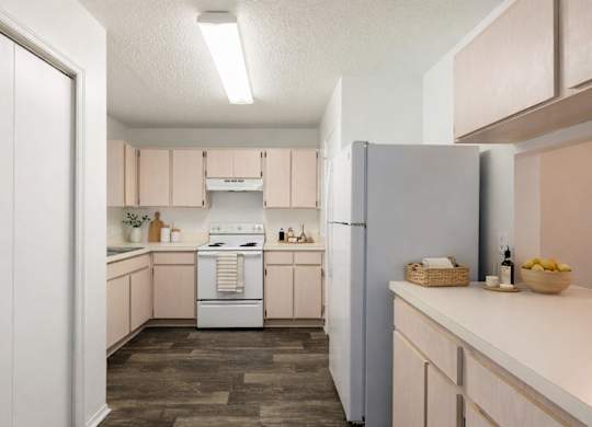 A kitchen with a white refrigerator and wooden floors.