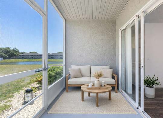 a screened-in patio with a chair and table