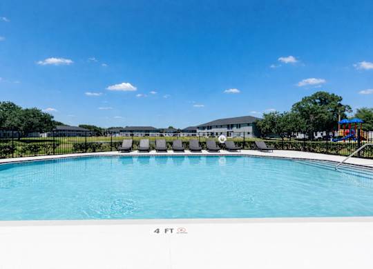 A swimming pool with a blue sky and clouds in the background.