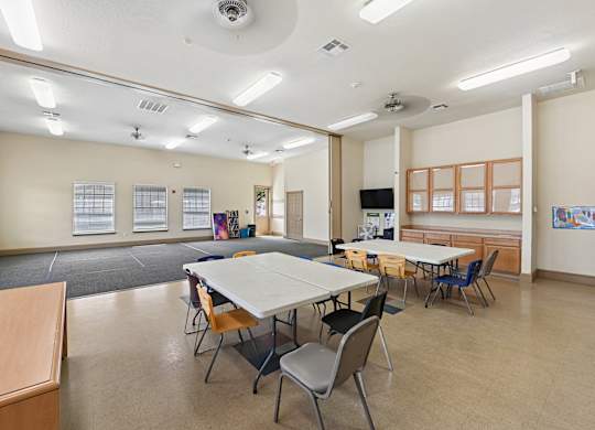 A classroom with tables and chairs and a whiteboard.