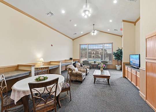 A spacious room with a table set for dining and a television.
