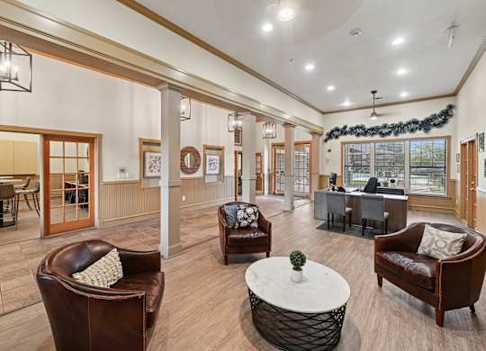 A living room with brown leather chairs and a white coffee table.