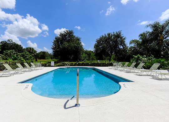 A large outdoor swimming pool surrounded by lounge chairs.
