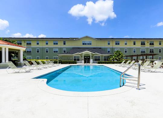 A large swimming pool in front of a hotel.