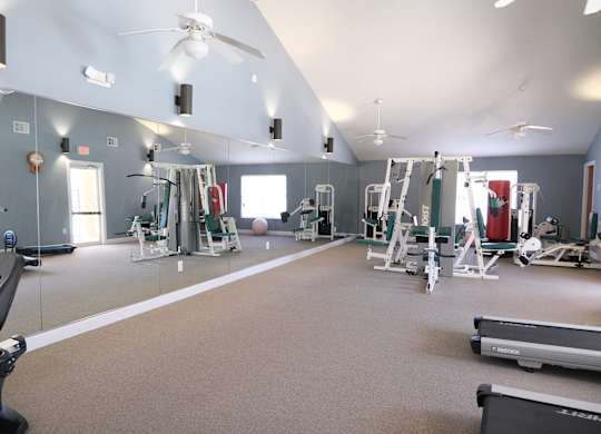 A spacious gym with a variety of equipment including treadmills, weights, and exercise machines.