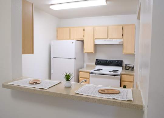 A small kitchen with a white fridge and a white oven.