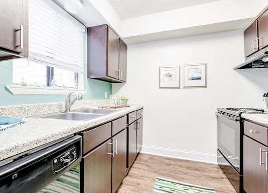 A kitchen with a sink, stove, and cabinets at Regency Park Apartment Homes, North Carolina