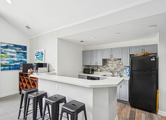A kitchen with a black fridge and white countertops at Regency Park Apartment Homes, Raleigh, 27616