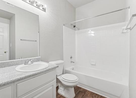 A white bathroom with a sink, toilet, and bathtub.