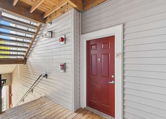 A red door with the number 207 on it.