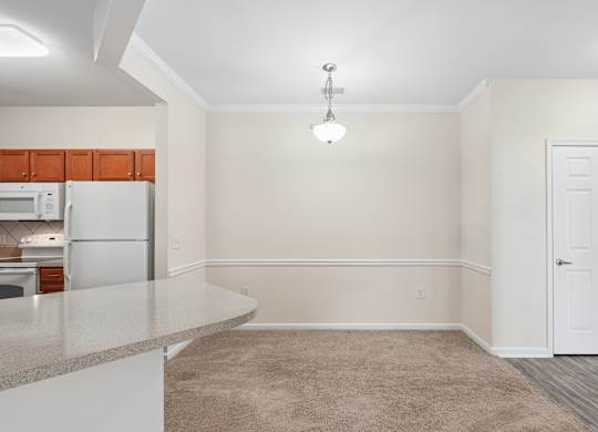 A kitchen with a refrigerator, cabinets, and a countertop.