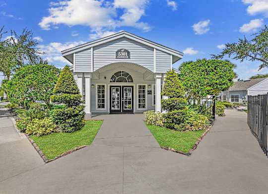 Exterior of leasing office surrounded by natural landscaping and a sidewalk