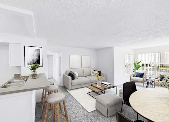Interior of apartment from kitchen area facing the living room couch and dining room table