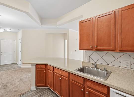 A kitchen with brown cabinets and a white sink.