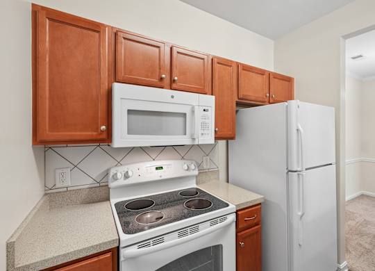 A kitchen with a white refrigerator, white microwave, and white stove.