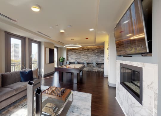 Resident sky lounge facing a pool table and sitting area complete with a television and fireplace.