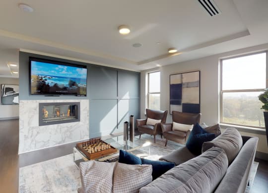 Resident sky lounge facing a table and sitting area complete with a television and fireplace.