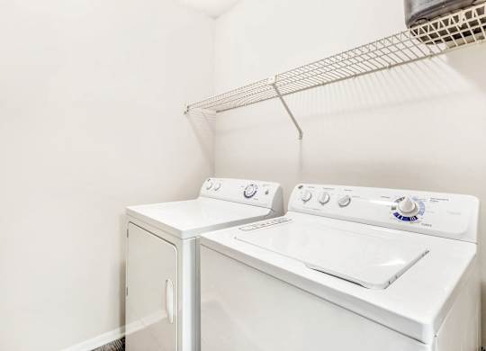 A white washing machine and dryer in a small laundry room.