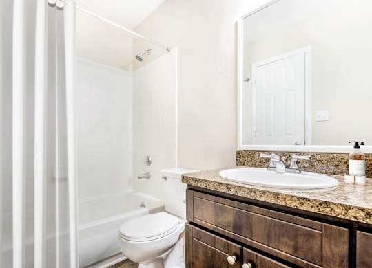 A white toilet sits next to a white sink in a bathroom.