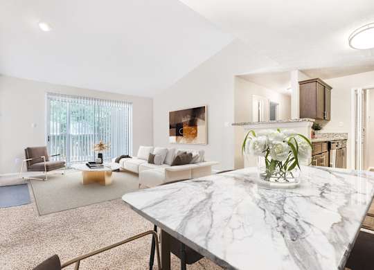 A living room with a marble table and a painting on the wall.