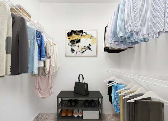 A clothing store with a variety of shirts and a handbag on a table.